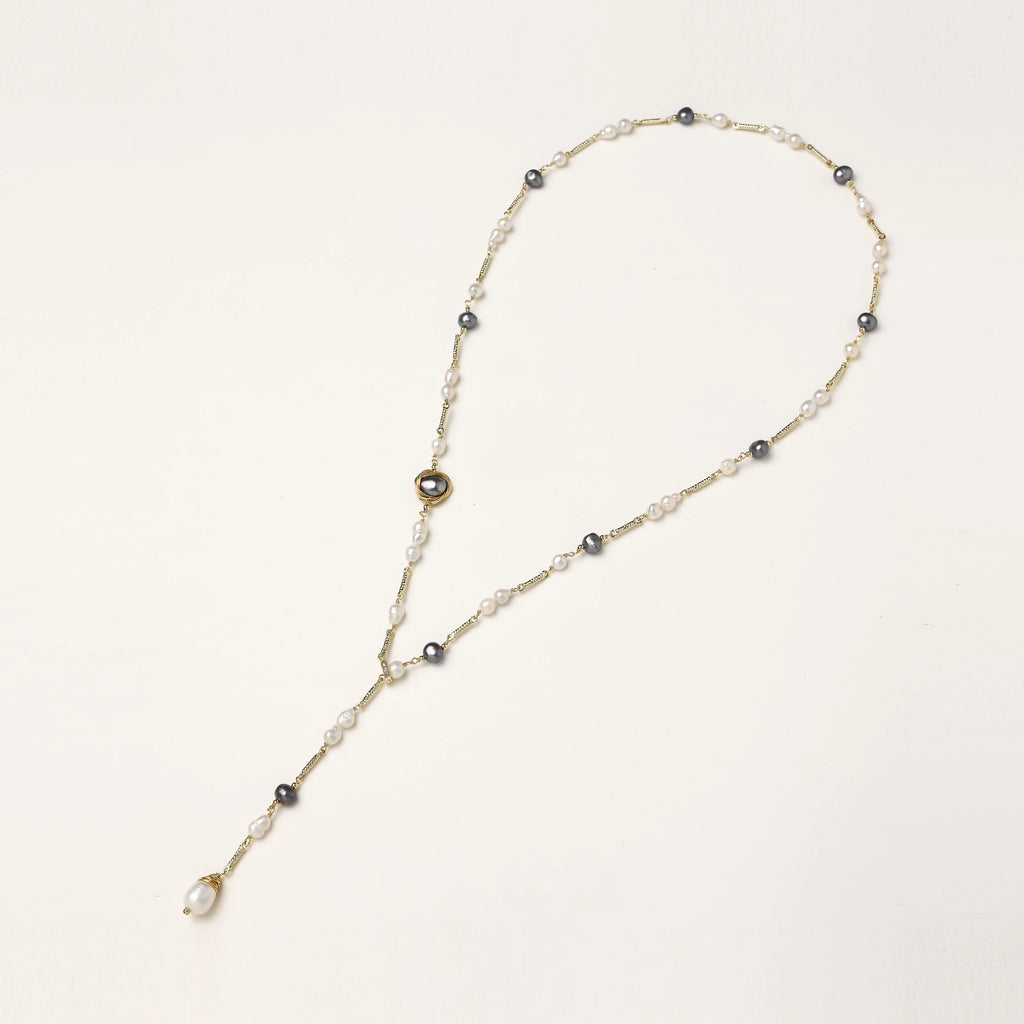 Long gold-plated necklace with alternating white and gray freshwater pearls spaced along delicate chain segments