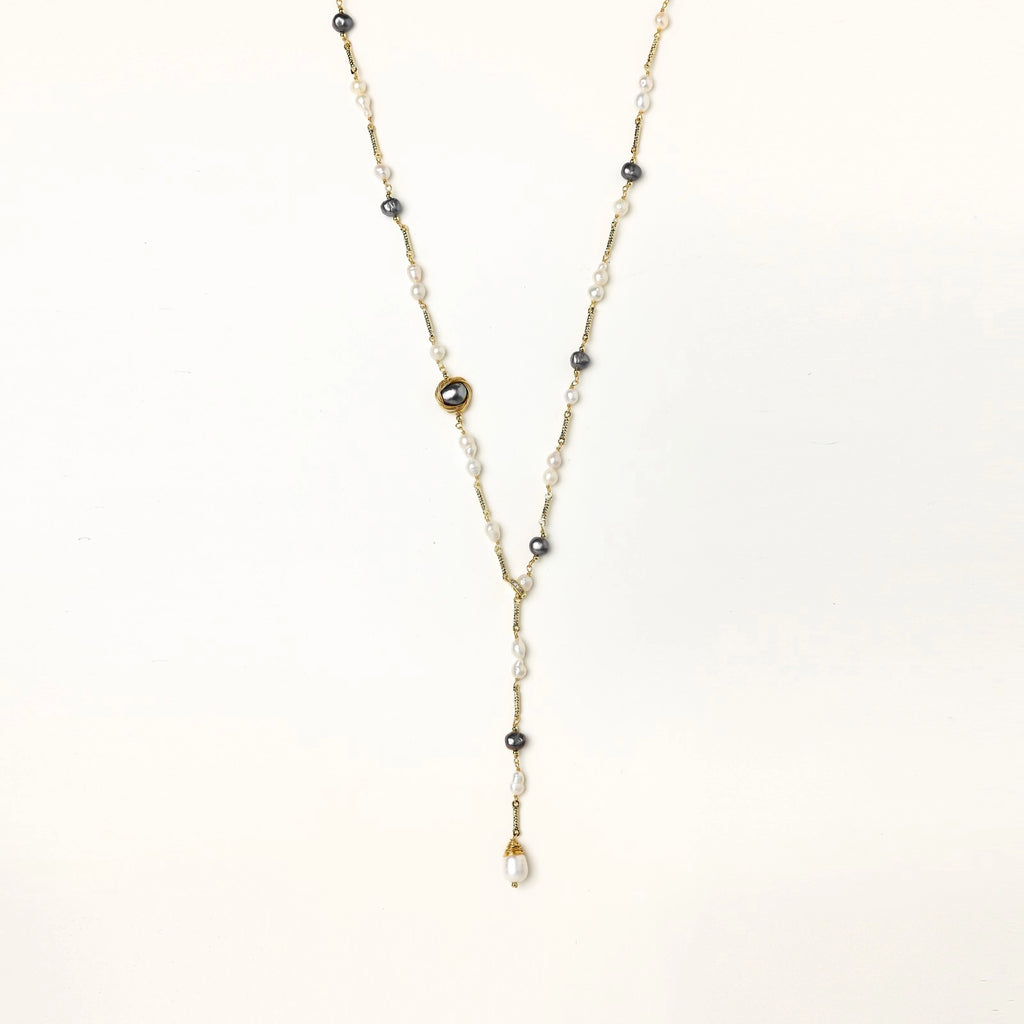 Long gold-plated necklace with alternating white and gray freshwater pearls spaced along delicate chain segments