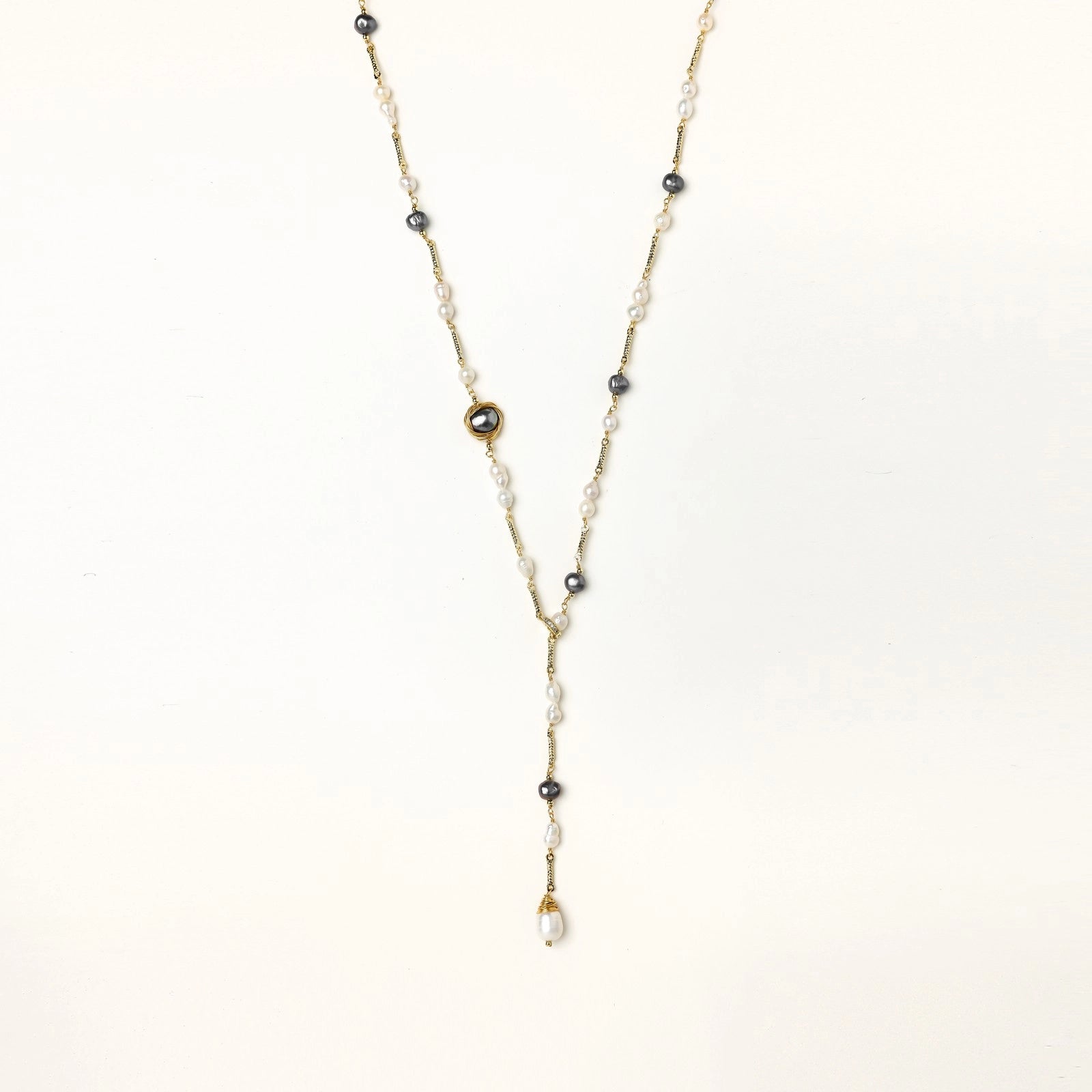 Long gold-plated necklace with alternating white and gray freshwater pearls spaced along delicate chain segments